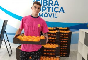 Cliente de Avanza Fibra recogiendo su caja de naranjas